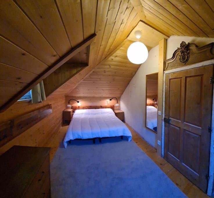 una grande camera da letto con un letto in una mansarda in legno di App. Lino nel cuore di Ortisei - casa dell'800 a Ortisei