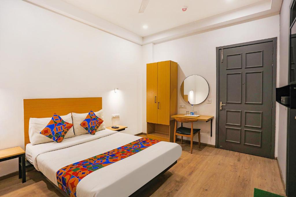 a bedroom with a large bed and a mirror at FabHotel Roseman in New Delhi