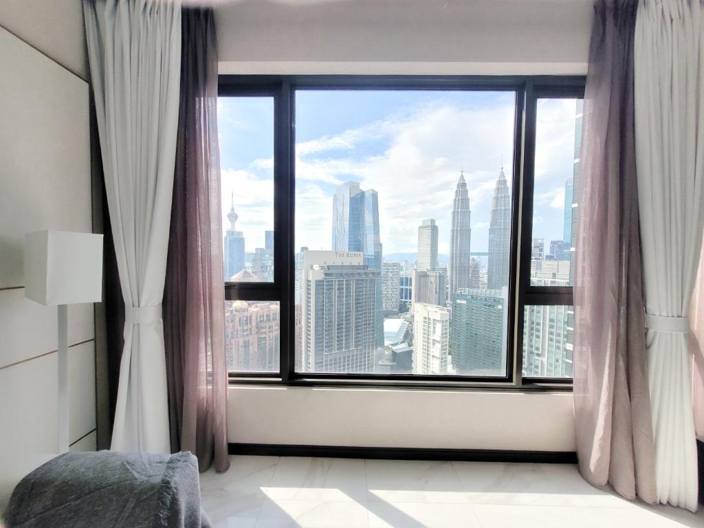 a room with a large window with a view of the city at 8 Kia Peng Residence Kuala Lumpur by Scape Stay in Kuala Lumpur