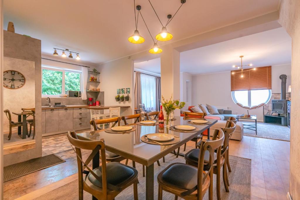 - une salle à manger et un salon avec une table et des chaises dans l'établissement Casa Nostalgia, à Poiana Brasov