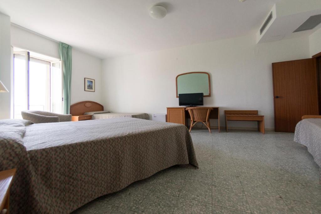 a hotel room with two beds and a mirror at Hotel Eden in San Domino
