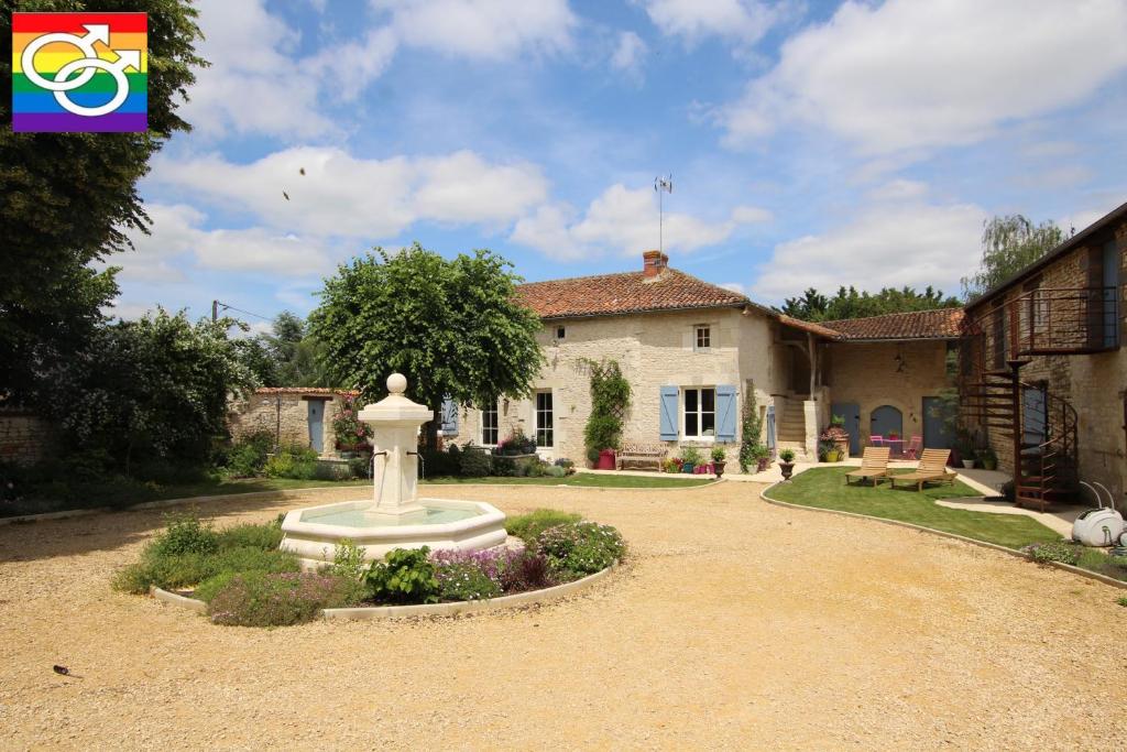 una casa con una fuente en medio de una entrada en Le Mas Pouantais GAYMEN ONLY en Pouant