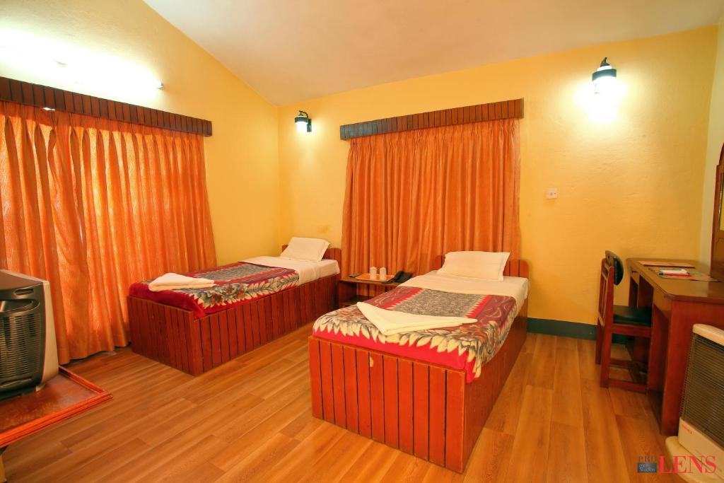 a hotel room with two beds and a tv at Melungtse apartment in Kathmandu