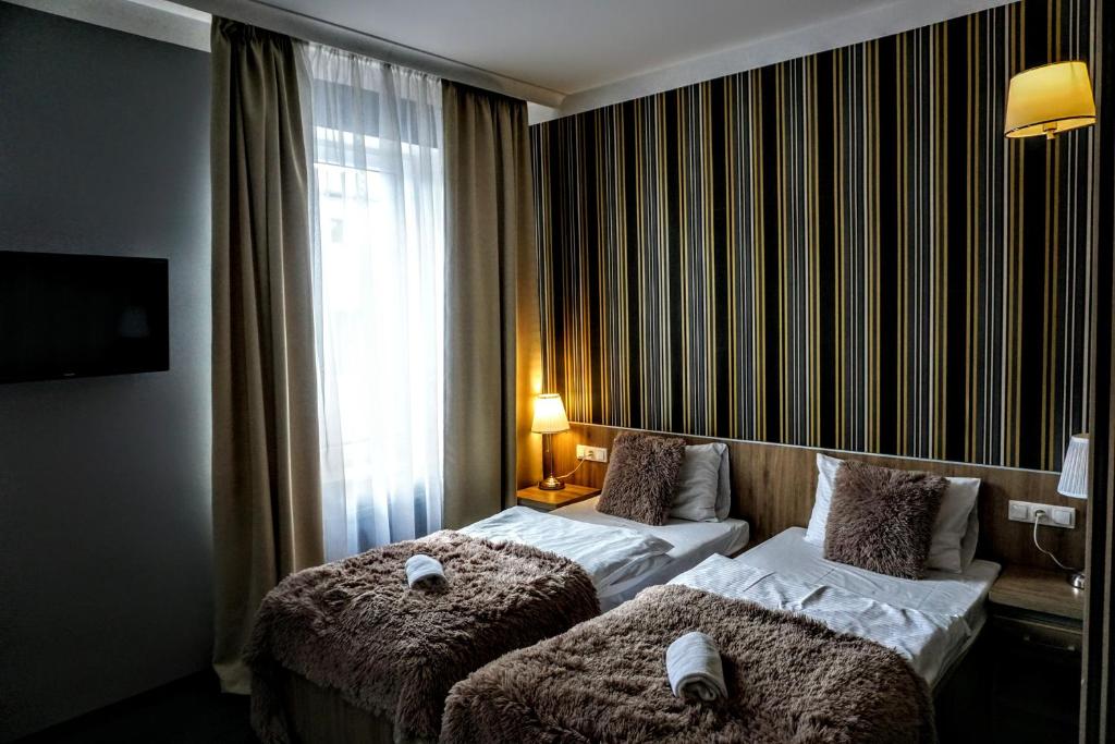um quarto de hotel com duas camas e uma janela em Aviator em Pabianice