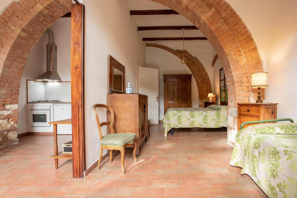 um quarto com 2 camas, uma mesa e cadeiras em Marzia - Agriturismo La Valentina em Talamone
