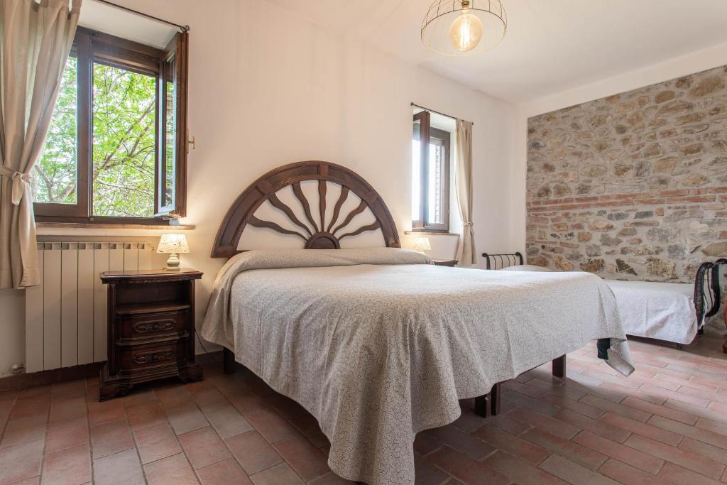 タラモーネにあるAngela - Agriturismo La Valentinaのレンガの壁、大きなベッド付きのベッドルーム1室