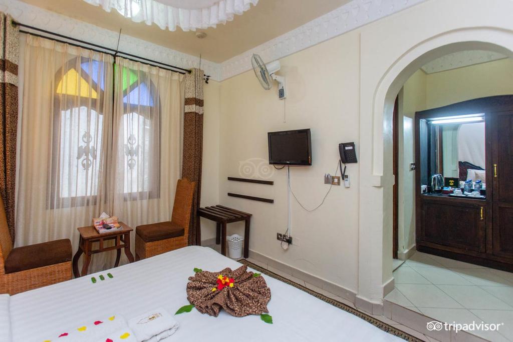 una camera da letto con un letto fiorito di Al-Minar Hotel a Zanzibar City