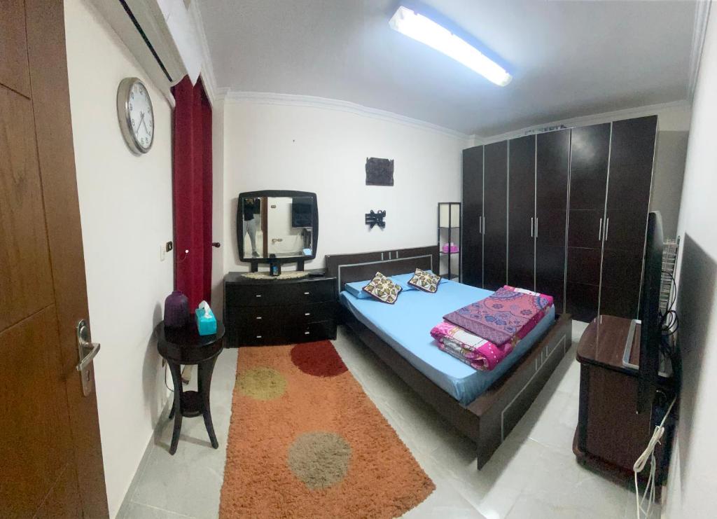 Your Home in Madinaty في Madīnat ash Shurūq: غرفة نوم بها سرير وتلفزيون