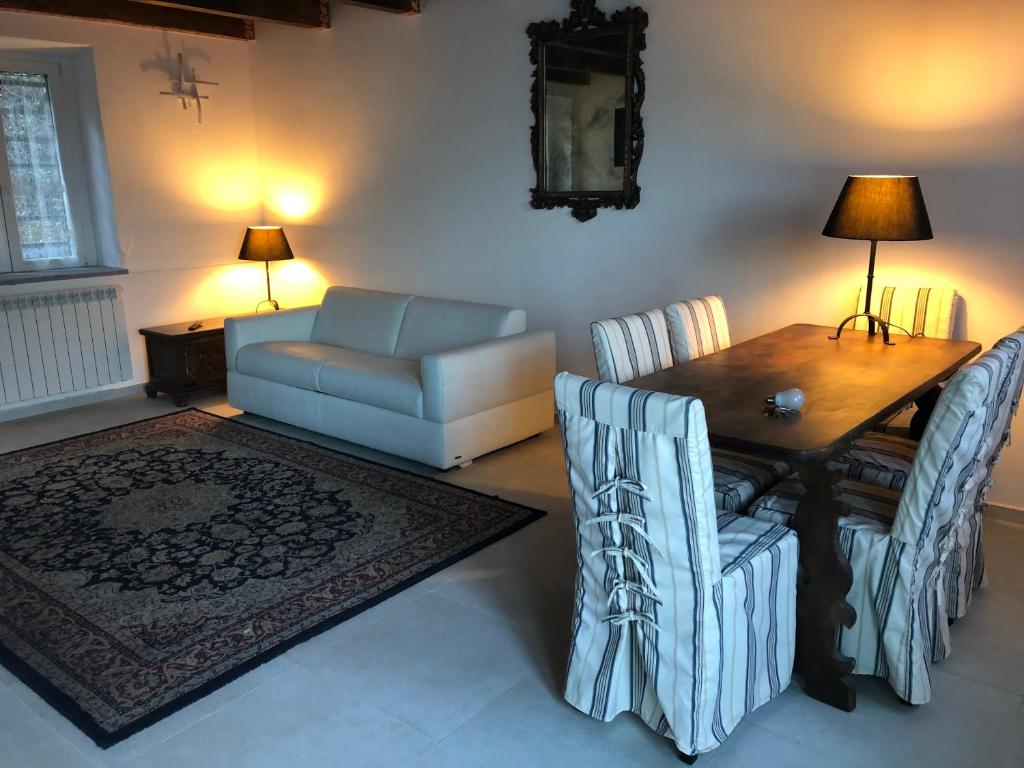 een woonkamer met een bank en een tafel en stoelen bij HomeSweetHome - Pavarolo ,TO, Italia in Pavarolo