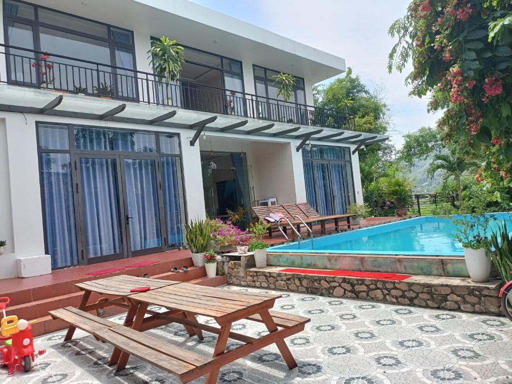 una casa con mesa de picnic y piscina en Hugo Homestay, en Phong Nha