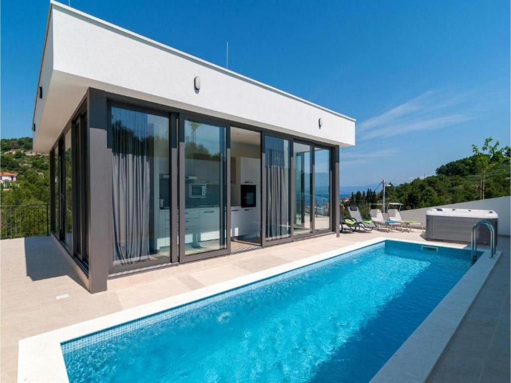 a house with a swimming pool in front of it at Villa Anđelina in Stomorska