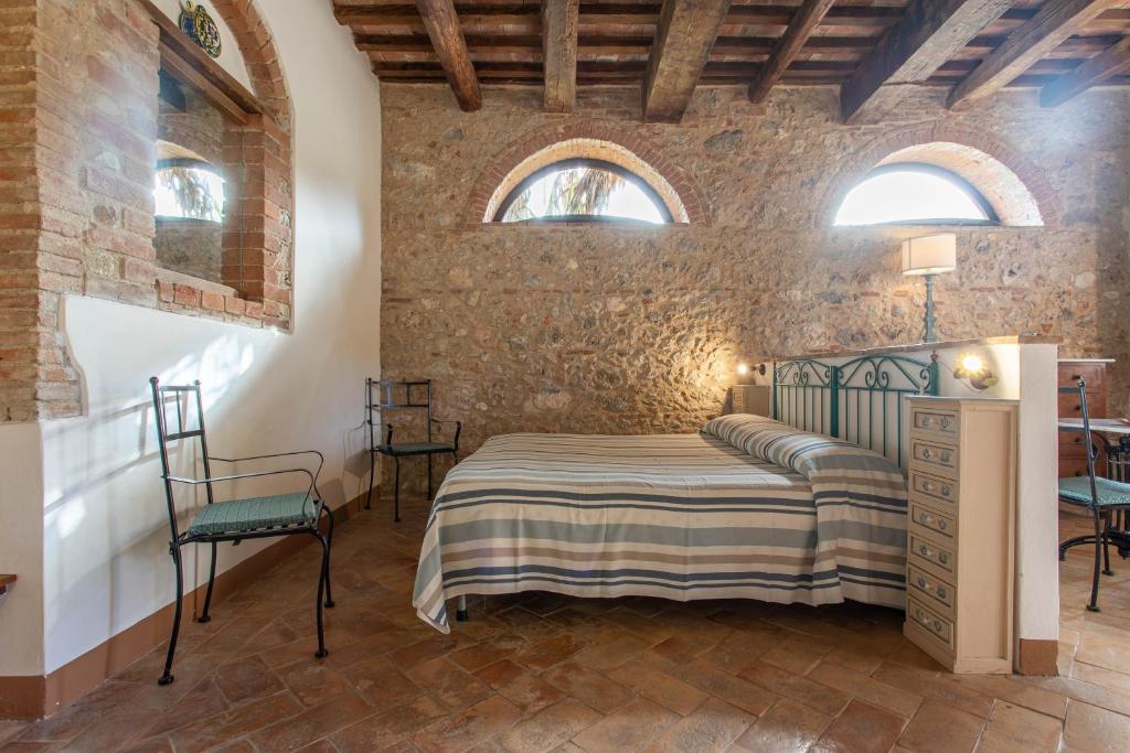 sypialnia z łóżkiem w ceglanej ścianie w obiekcie Clementina-agriturismo la Valentina w mieście Talamone