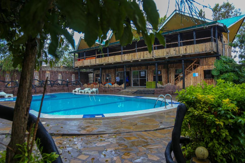 a large swimming pool in front of a building at Dovenest Lodge in Naivasha