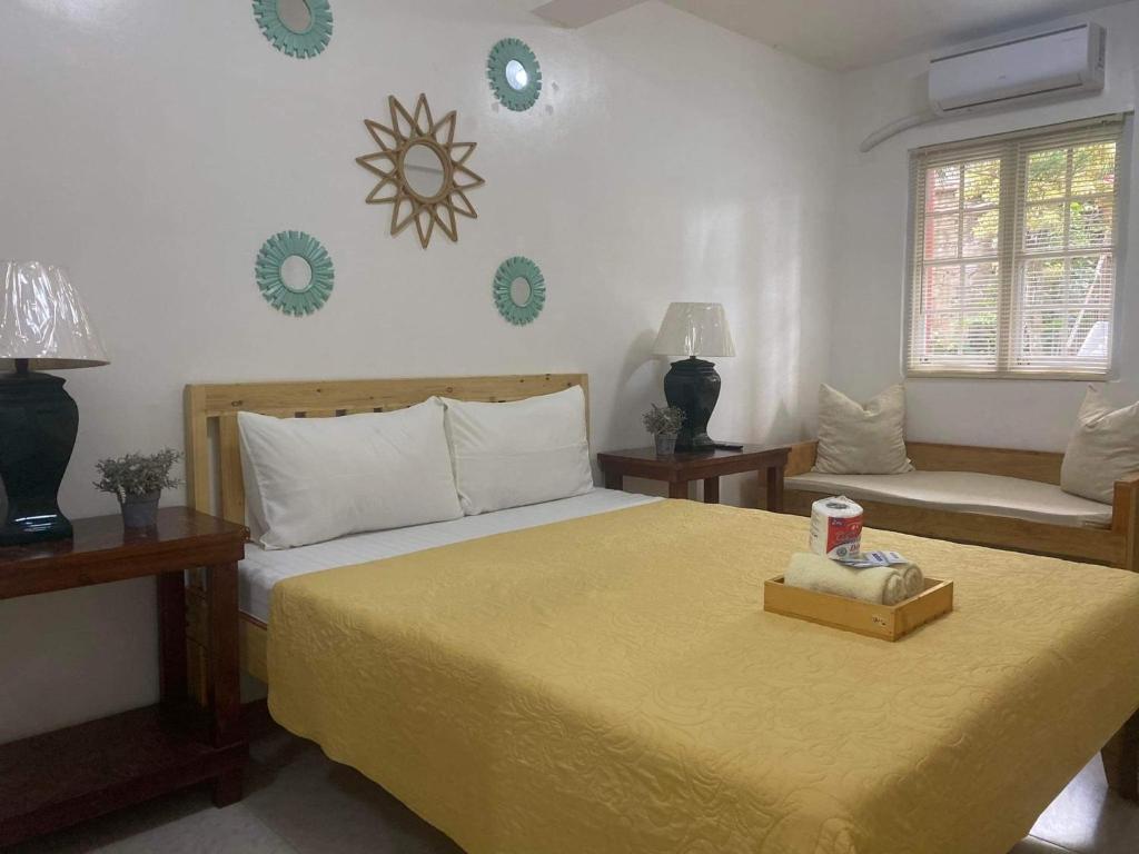 1 dormitorio con 1 cama con colcha amarilla en Pensio de Felipe en Tagaytay