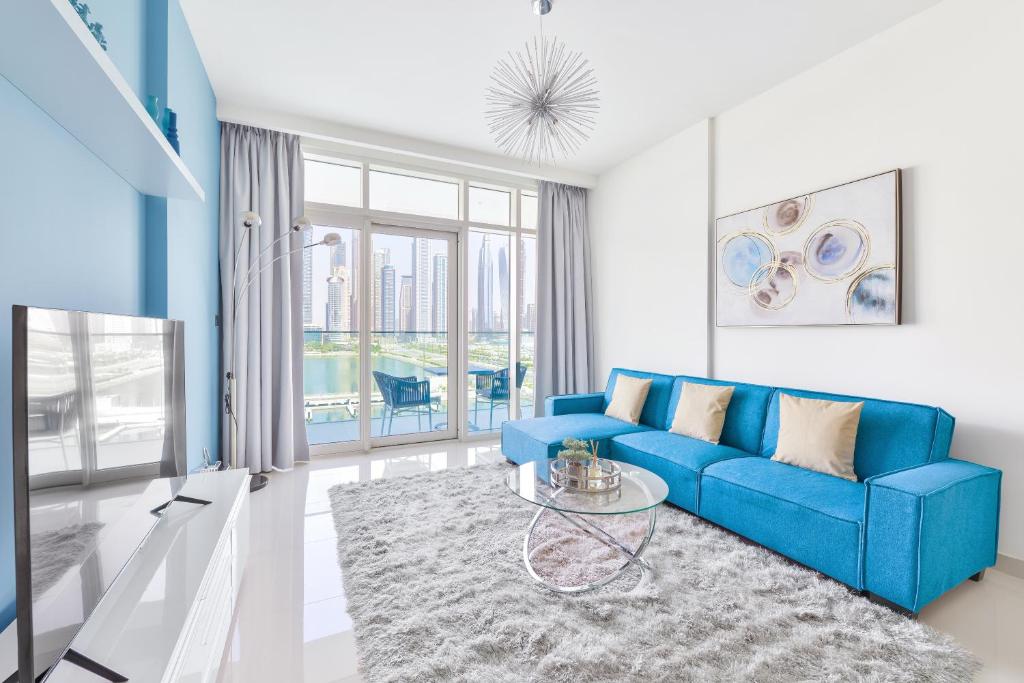 een woonkamer met een blauwe bank en een tafel bij Ultra Luxury Emaar Beachfront - Private Beach and Pool in Dubai