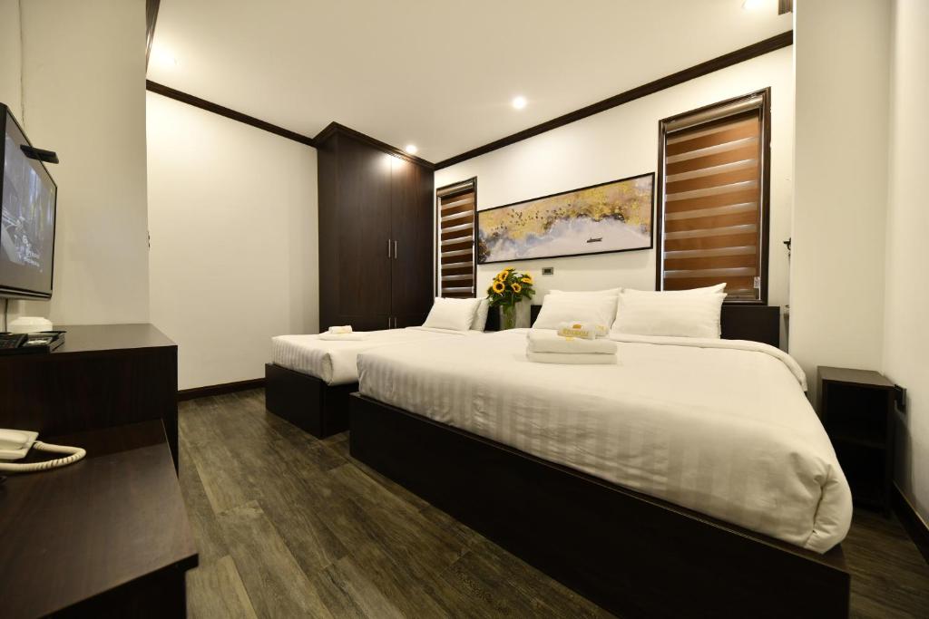 Postel nebo postele na pokoji v ubytování Kingdom Hotel Hanoi