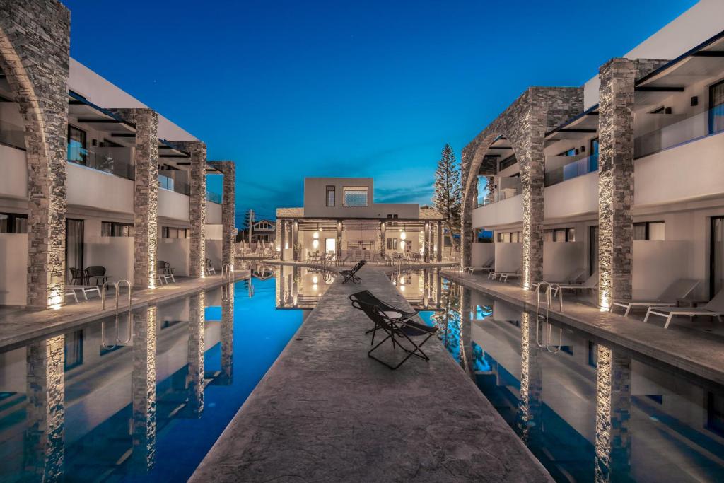 a pool with a bench in the middle of a building at Cavo di Suites in Kalamaki