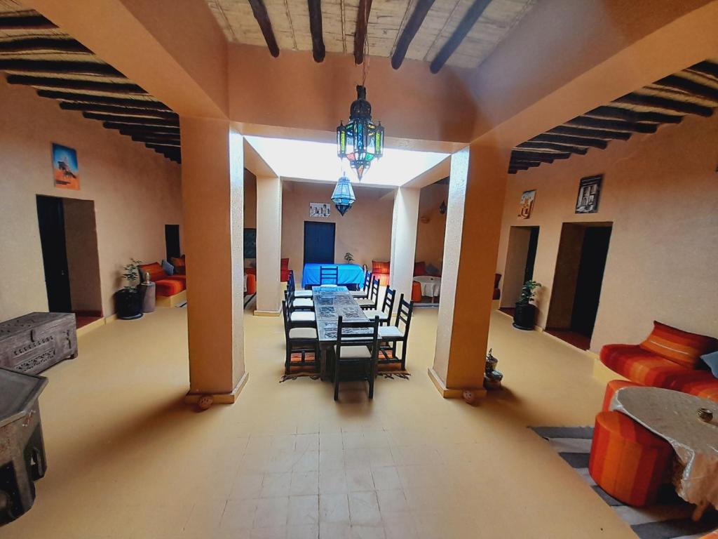 uma sala de jantar com uma mesa e cadeiras num quarto em Gite d'étape nomade em Tajda
