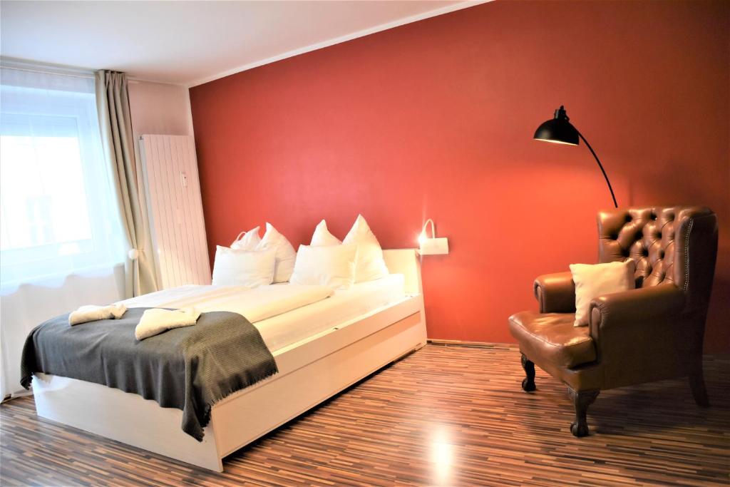 um quarto vermelho com uma cama e uma cadeira em Studio-Apartment Augarten em Viena