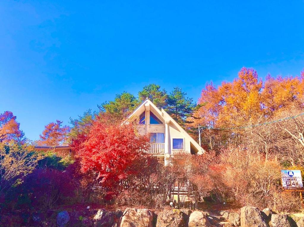 een huis omgeven door bomen met herfstbladeren bij Polar Haus Canadian NishiKaruisawa1 - Vacation STAY 07669v in Oiwake