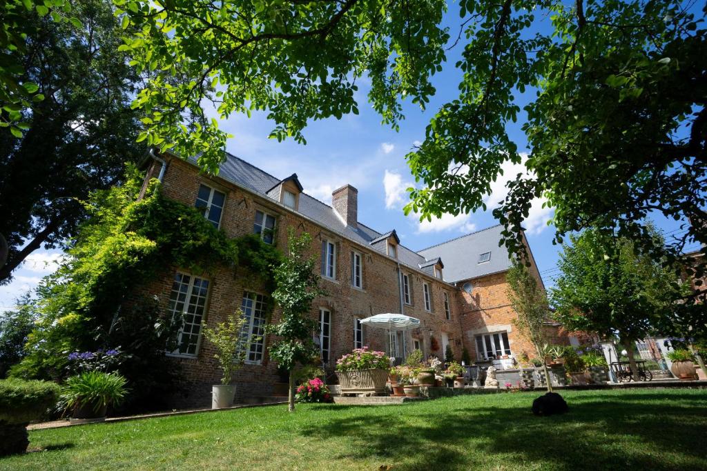 un grand bâtiment en briques avec une pelouse devant lui dans l'établissement Au Chantecler, 