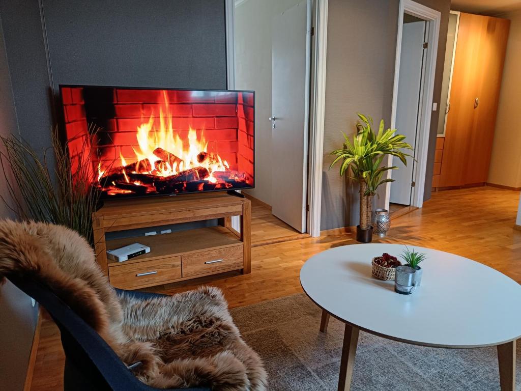 a living room with a fireplace and a table at Apartment right in the city centre in Stavanger