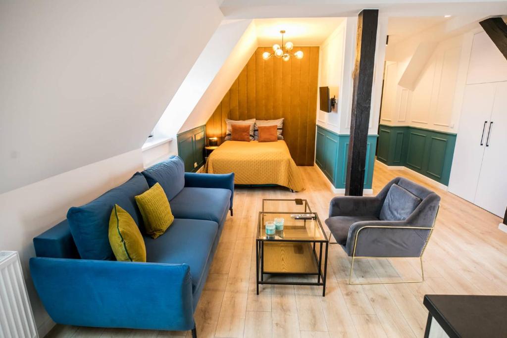 a living room with a blue couch and a bed at Loft 38 z tarasem in Toruń