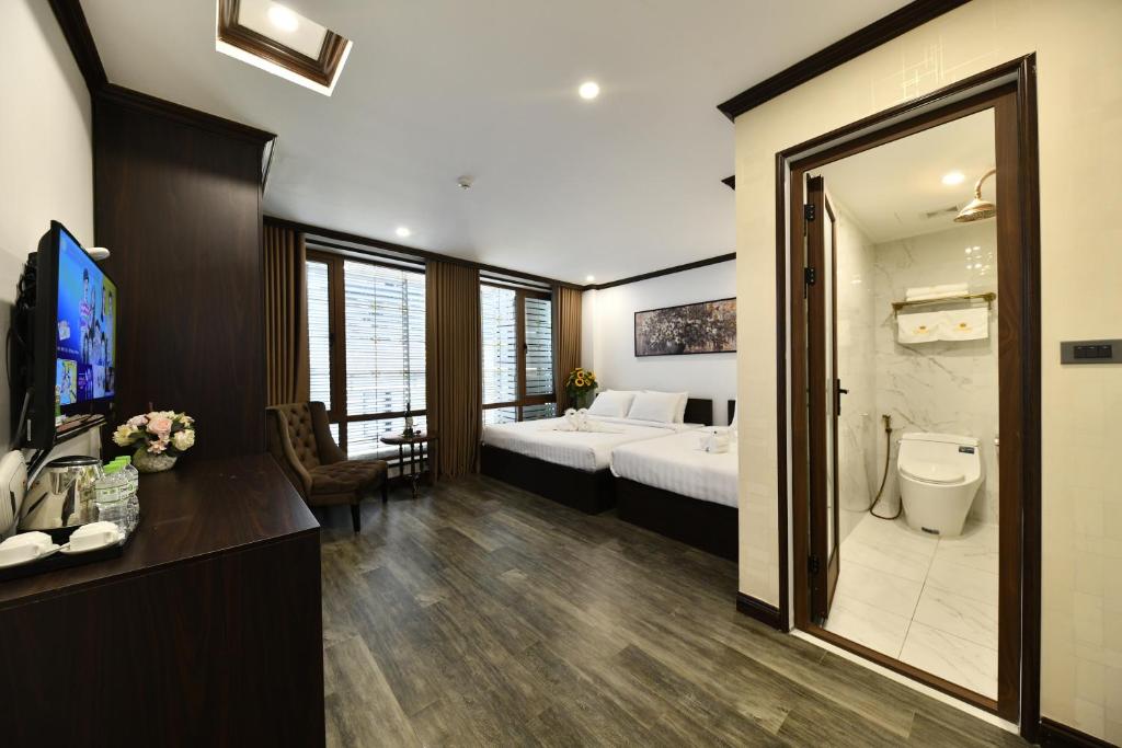 Postel nebo postele na pokoji v ubytování Kingdom Hotel Hanoi