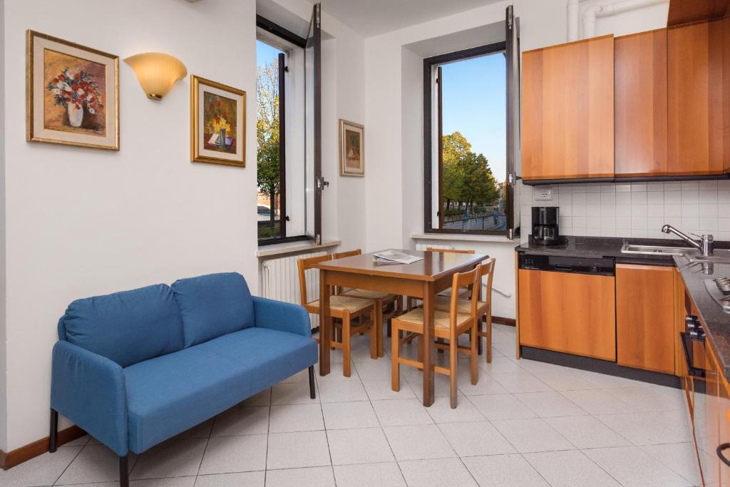 une cuisine avec un canapé bleu et une table dans l'établissement Flats4rent Regaste, à Vérone