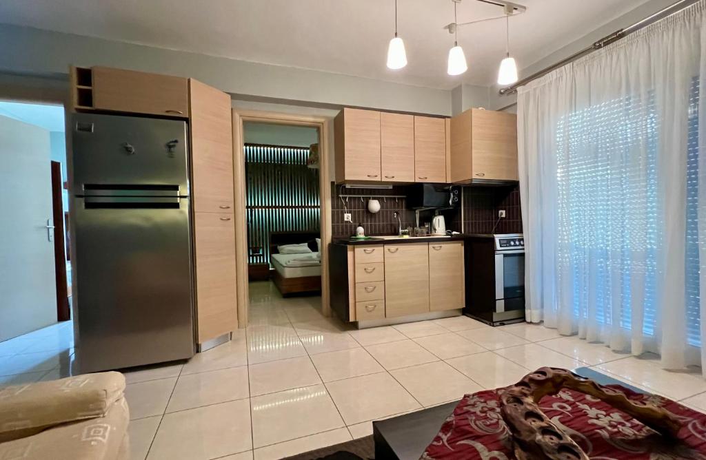 a kitchen with a stainless steel refrigerator and cabinets at Luxury Equiped Apartment - Olympic Beach in Olympiaki Akti