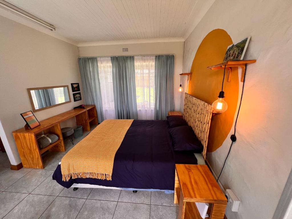 a bedroom with a bed and a table and a mirror at Firefly Budget Friendly Guest House in Kempton Park