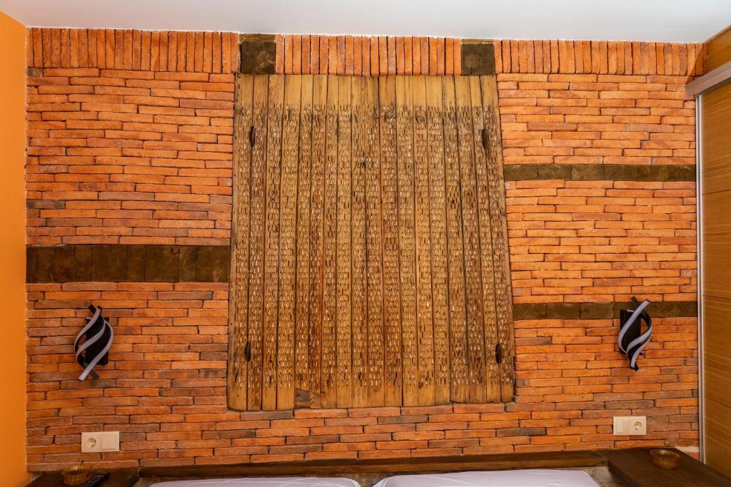 Una pared de ladrillo con una cortina. en La Casona de Trescasas, en Sonsoto