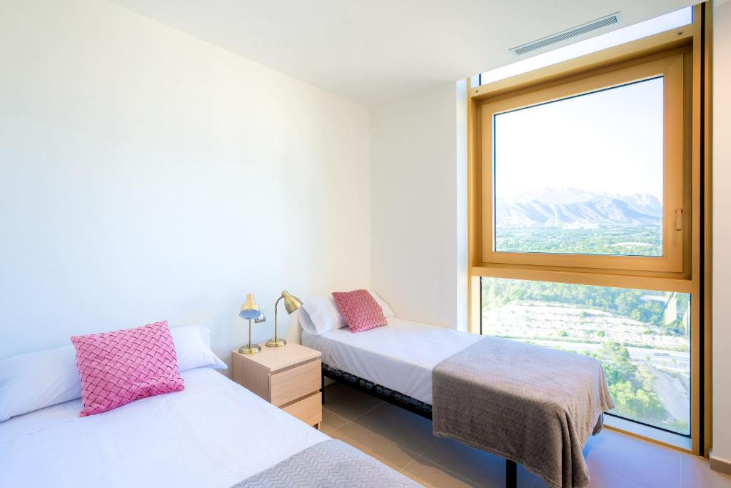 1 dormitorio con 2 camas y ventana grande en Intempo Sky Apartments 154 en Benidorm