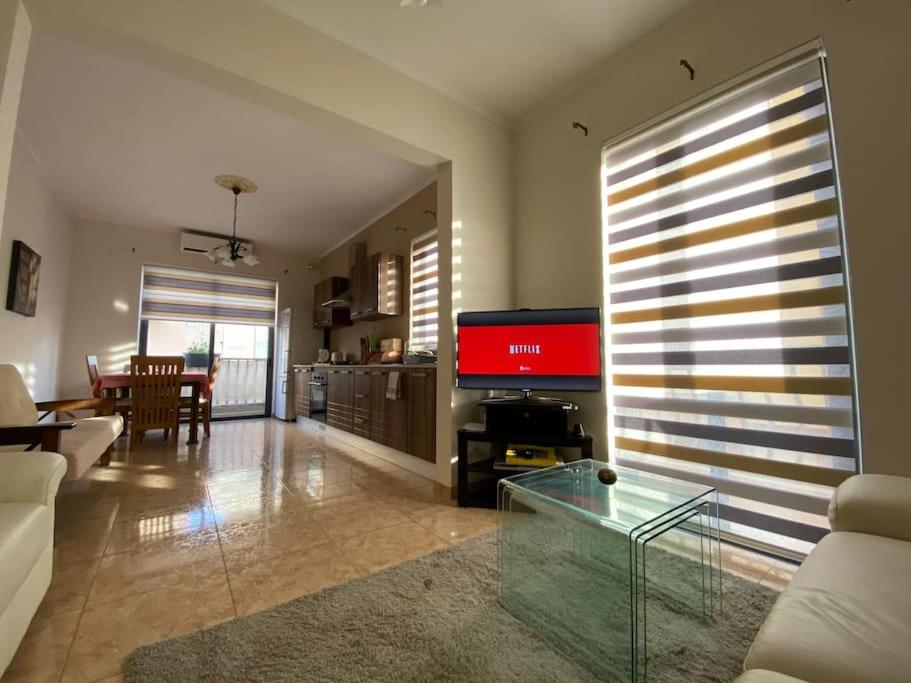 een woonkamer met een bank, een televisie en een tafel bij May Flower: Modern Flat close to Airport/Bus Stops in Tarxien