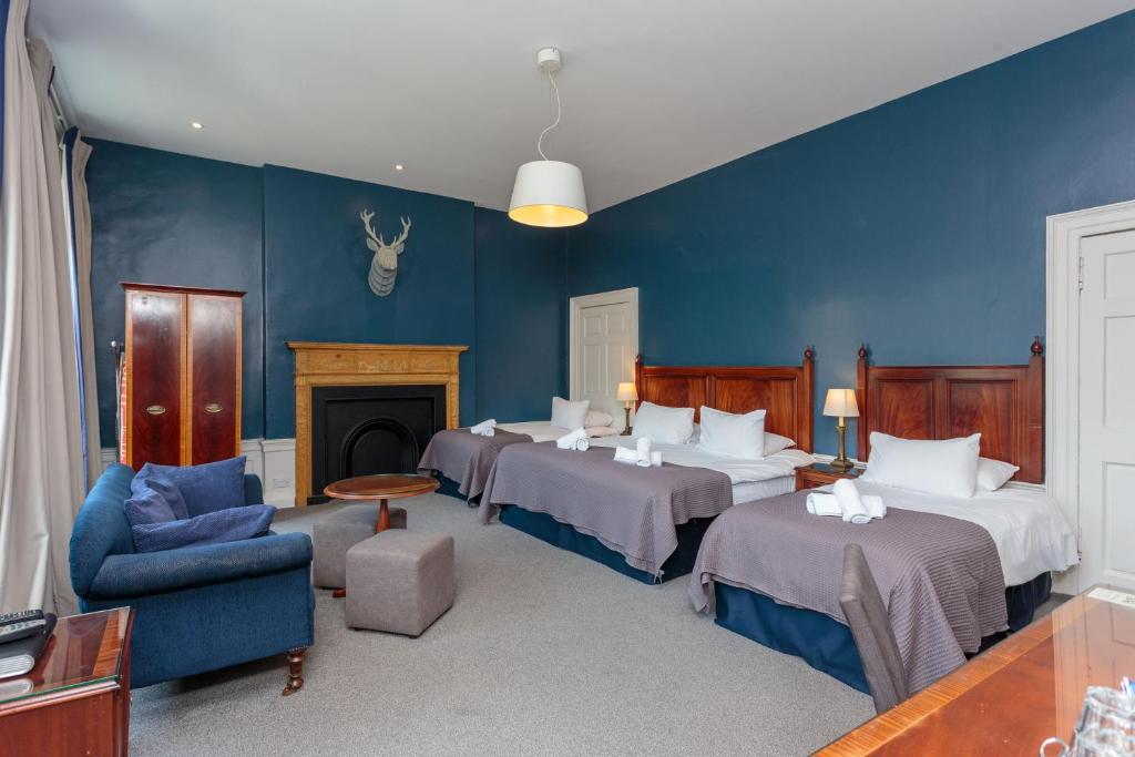 a room with three beds and a fireplace at No. 53 Frederick Street in Edinburgh