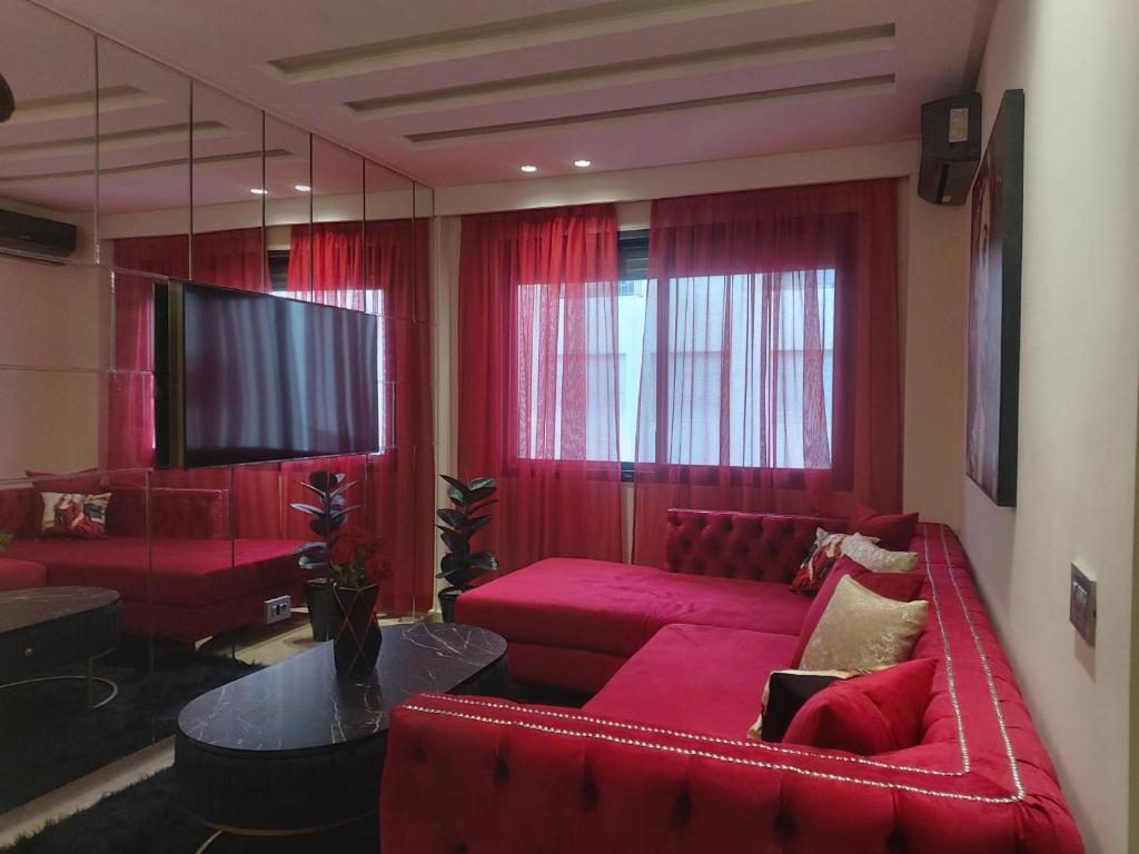 sala de estar con sofás rojos y TV de pantalla plana en The Mask 2 Bed Room with rooftop Swimming pool, en Casablanca