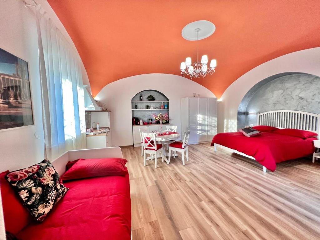 a bedroom with a red bed and a table at IL CASALE POMPEIANO in Pompei