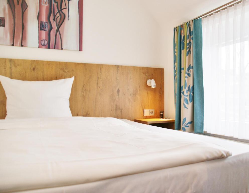 Postel nebo postele na pokoji v ubytování Taste Smart Hotel Backnang
