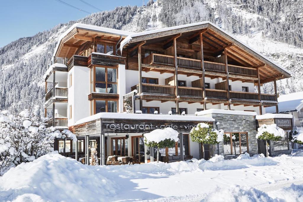 un gran edificio en la nieve con una montaña en HUBER's Boutiquehotel, en Mayrhofen