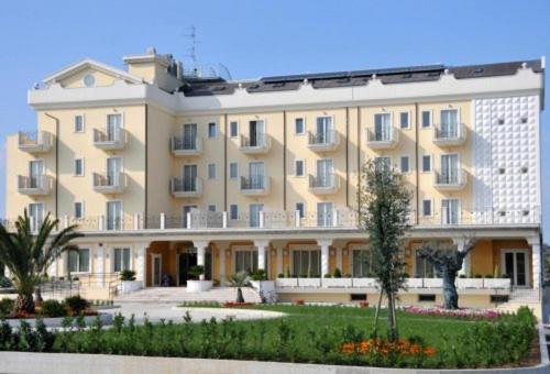 duży budynek apartamentowy z ogrodem przed nim w obiekcie HOTEL CONCORDE w mieście SantʼEgidio alla Vibrata