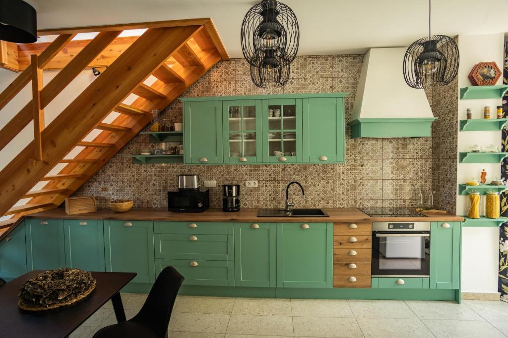 a kitchen with green cabinets and a staircase at Bled House Of Green in Bled