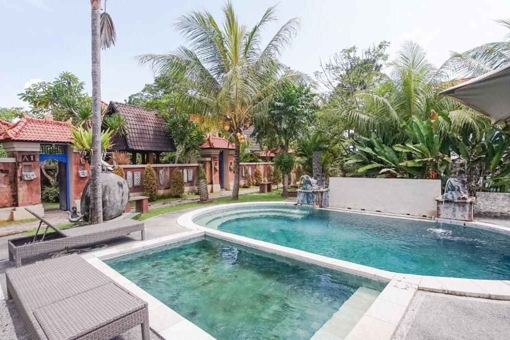 a swimming pool in the backyard of a house at Nirmala Guest House Surf Keramas in Keramas