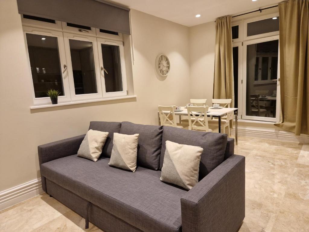 ein Wohnzimmer mit einem Sofa und einem Tisch in der Unterkunft Spacious 2 BR with Balcony in Hendon in Colindale