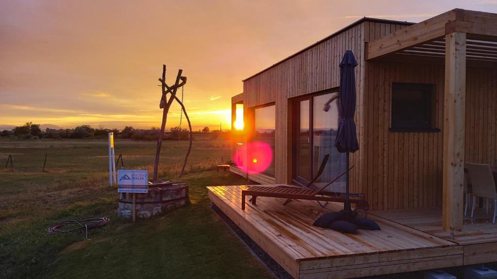 Cabaña de madera con puesta de sol en el fondo en Zimmerei - Landgasthaus Karlo en Illmitz