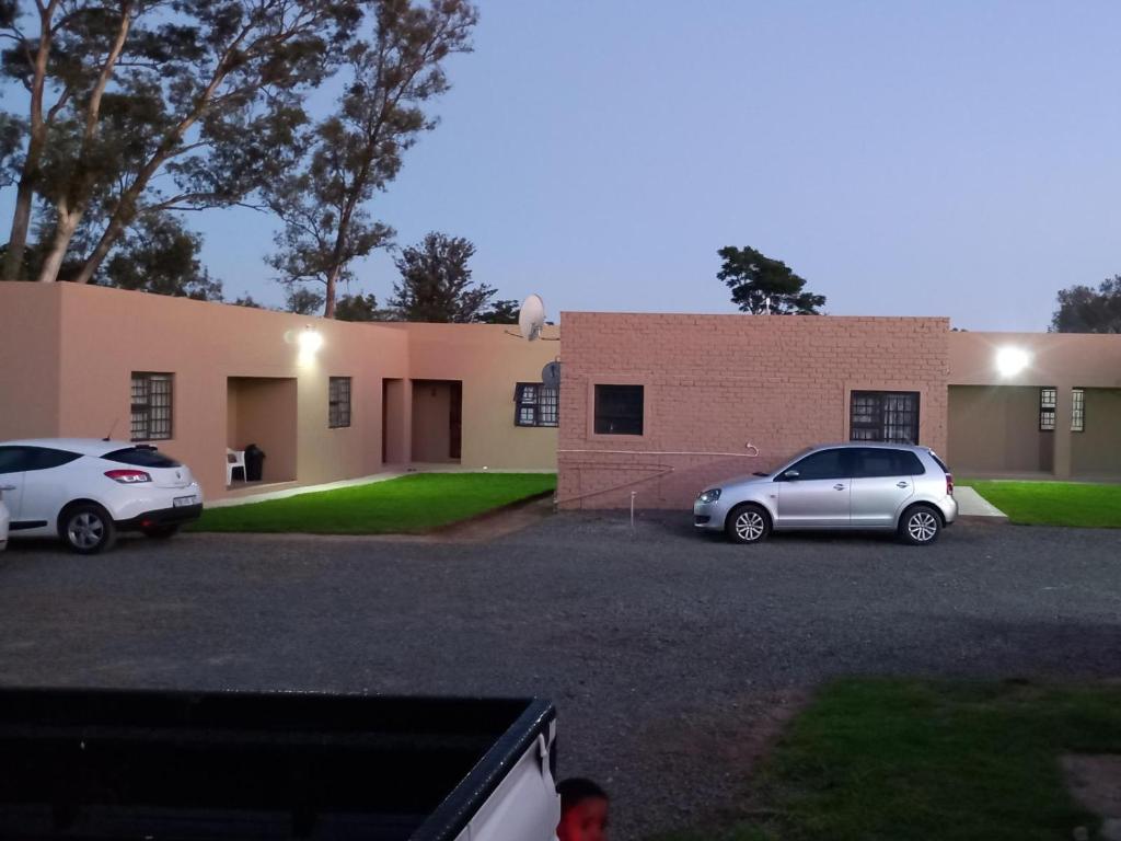 two cars parked in a parking lot in front of a building at Claytons accommodation in Bedford