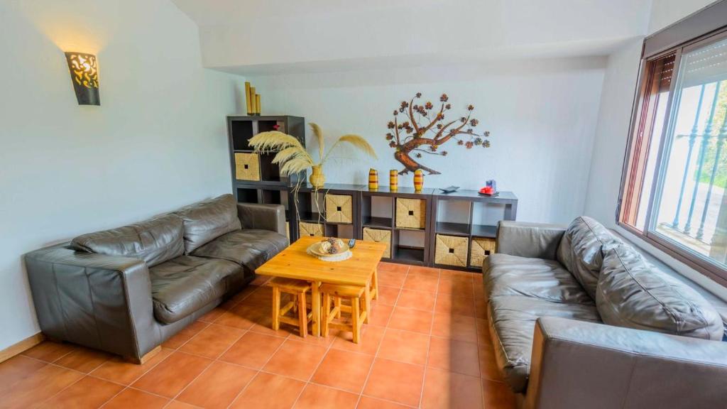 a living room with a leather couch and a table at Casa Diego Piña Júzcar by Ruralidays in Júzcar