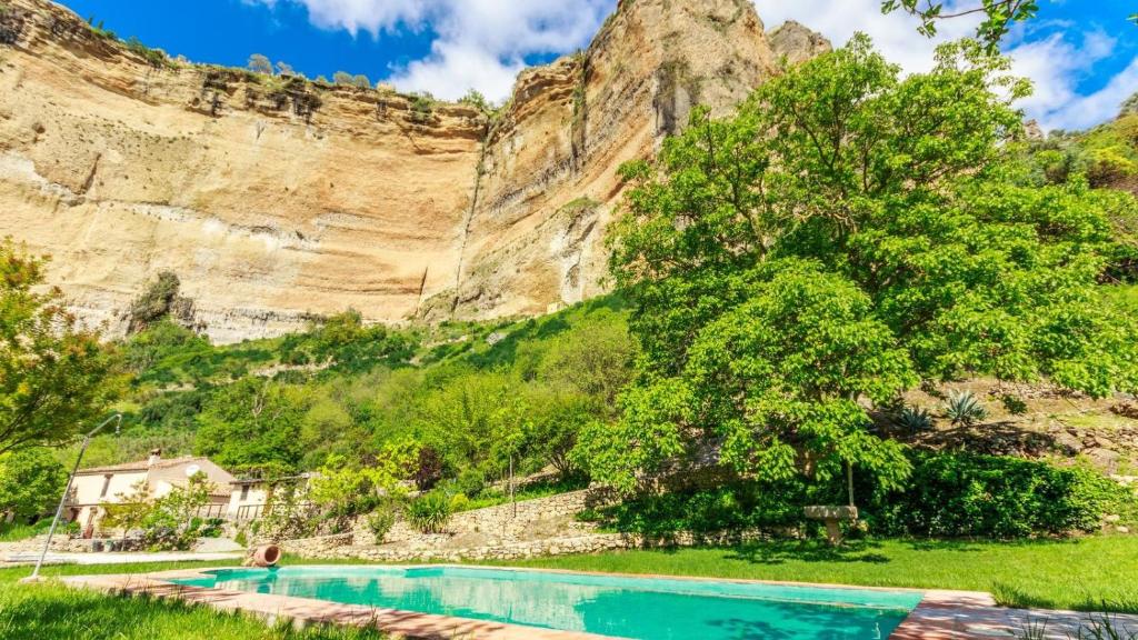 a swimming pool in front of a mountain at La Huerta del Tajo - Grande Ronda by Ruralidays in Ronda