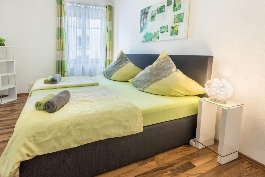 Schlafzimmer mit einem Bett mit gelber Bettwäsche und Kissen in der Unterkunft Ferienwohnung Stachel A in Konstanz
