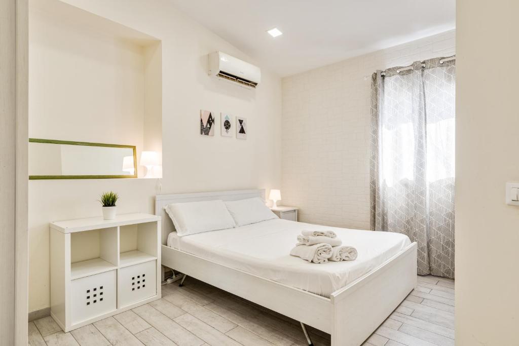 カターニアにあるCatania Modern Beige Apartmentの白いベッドルーム(白いベッド1台、窓付)