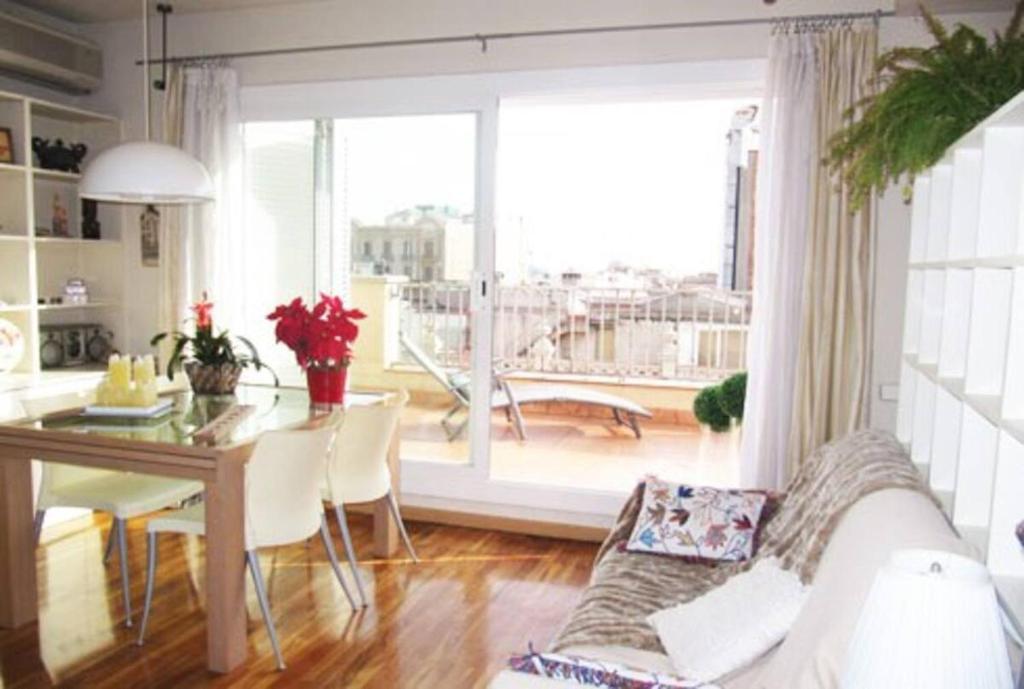 شقق توب برشلونة في برشلونة: غرفة معيشة مع أريكة بيضاء وطاولة وغرفة طعام
